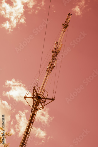 Mobile Cellular Phone System Antenna on Orange Sky and White Clouds.