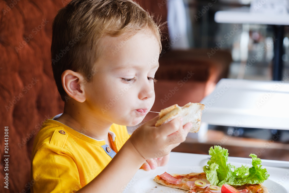 Little boy eating a small pizza Little boy eating a small pizza