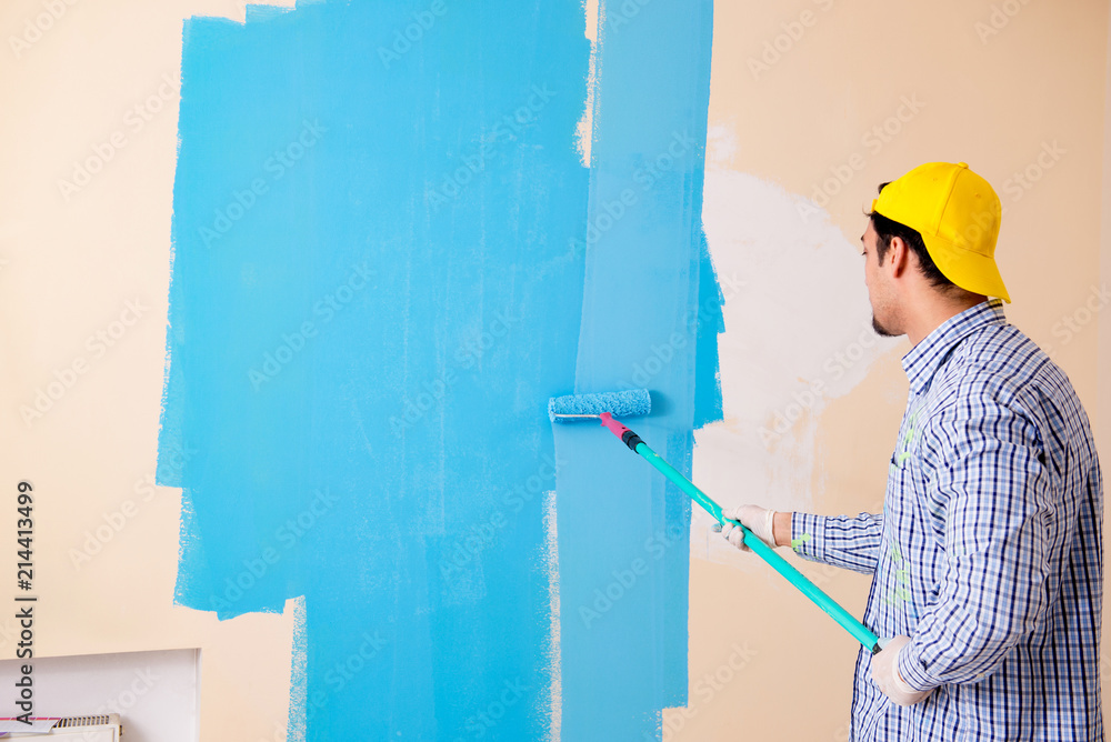 Painter man painting the wall at home Painter man painting the wall at home