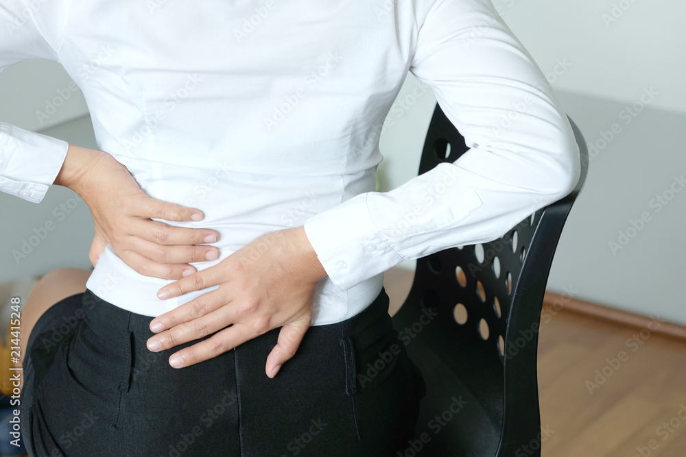 young woman sitting have back pain and sore waist concept of pain relief and health care young woman sitting have back pain and sore waist concept of pain relief and health care