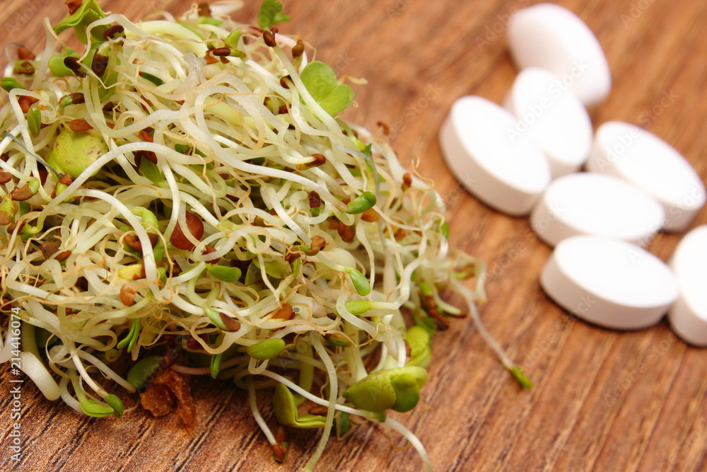 Alfalfa and radish sprouts with tablets supplements, choice between healthy eating and pills Alfalfa and radish sprouts with tablets supplements, choice between healthy eating and pills