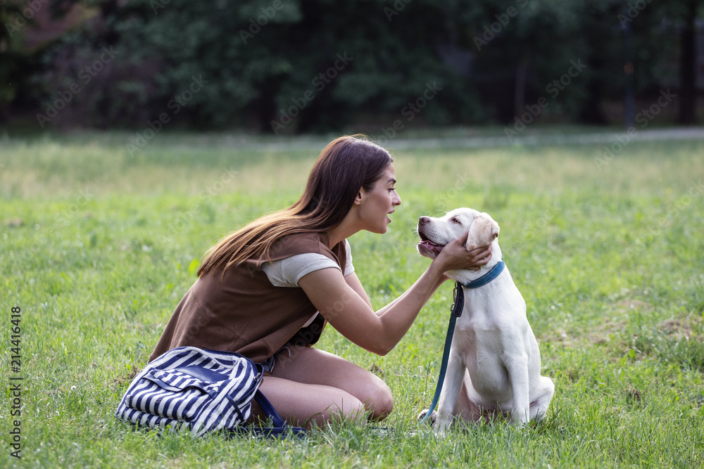 Young woman with dog on park sitting on the grass and play Young woman with dog on park sitting on the grass and play