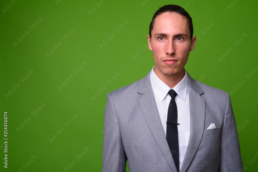 Young handsome businessman against green background Young handsome businessman against green background