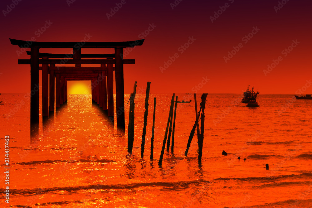 silhouette torii wooden Japanese pillar stand on over the sea and sunset sky