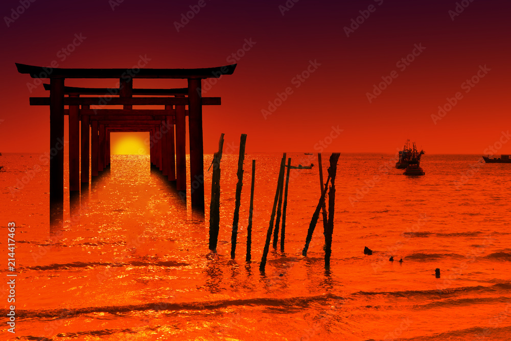 Naklejka premium silhouette torii wooden Japanese pillar stand on over the sea and sunset sky