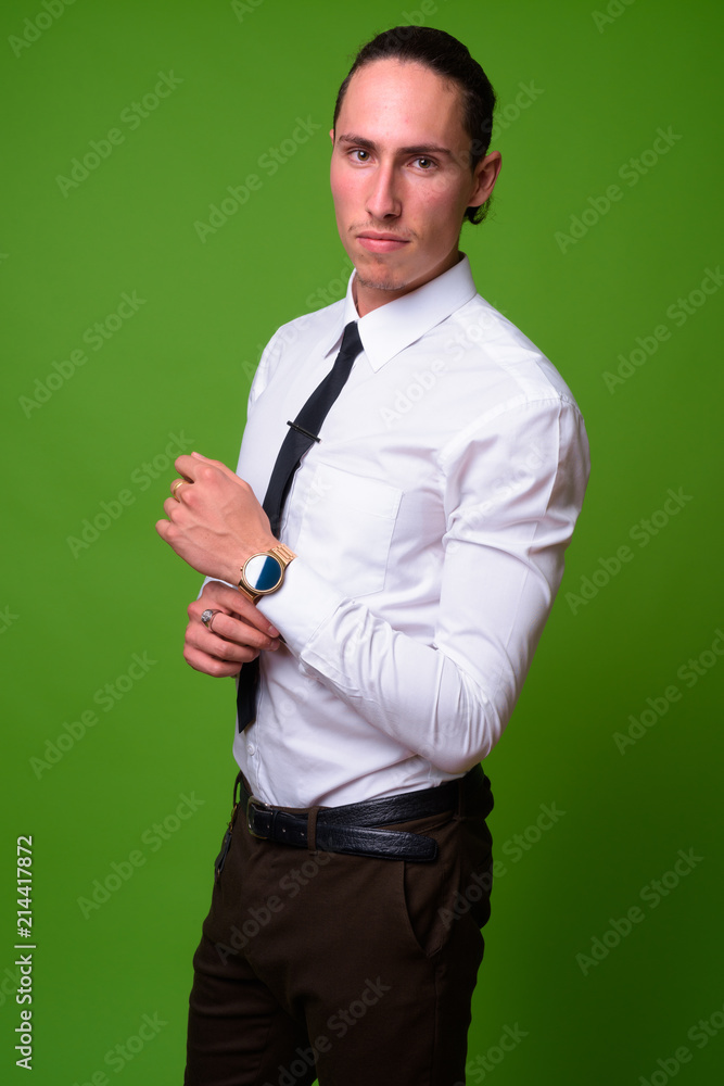 Young handsome businessman against green background Young handsome businessman against green background