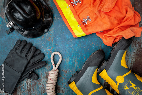 Outfit of Firefighter placed on old table background, Fire equipment concept.