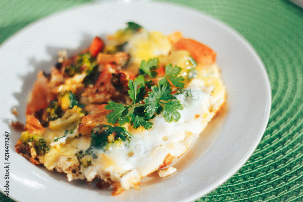 Scrambled eggs with tomatoes and greens on green background Scrambled eggs with tomatoes and greens on green background