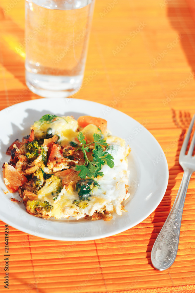 Scrambled eggs with tomatoes and greens on an orange background Scrambled eggs with tomatoes and greens on an orange background