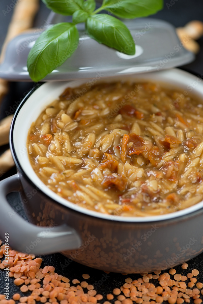 Close-up of italian soup with red lentils and pasta in a pot, selective focus Close-up of italian soup with red lentils and pasta in a pot, selective focus
