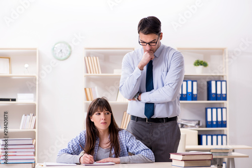 Male lecturer giving lecture to female student photo