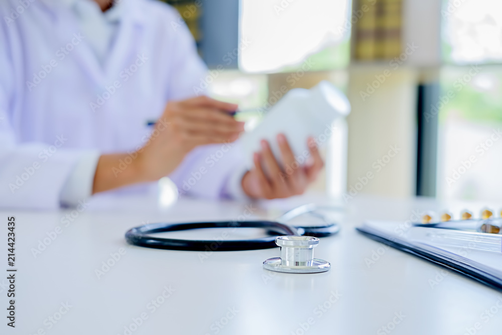 Fototapeta premium Stethoscope with clipboard and Laptop on desk, Doctor working in hospital writing a prescription, Healthcare and medical concept, test results in background,