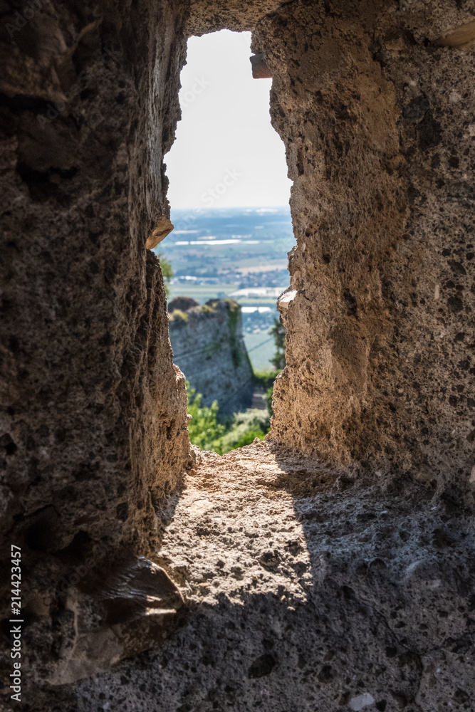 Vertical view of the landscape from an ancient medieval stone wall window. No people.