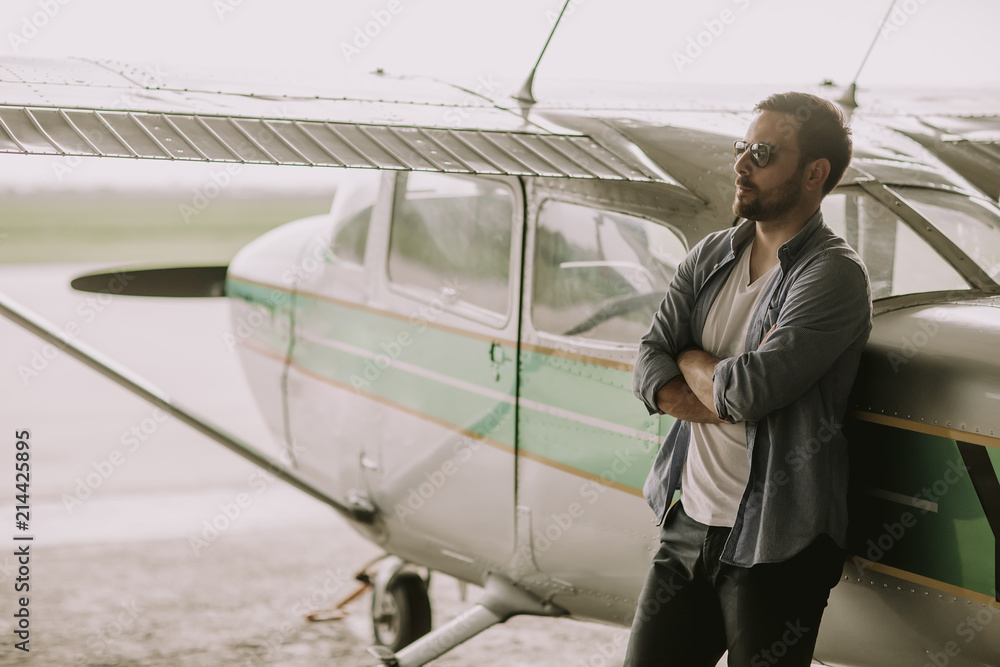 Young pilot checking ultralight airplane before flight Young pilot checking ultralight airplane before flight