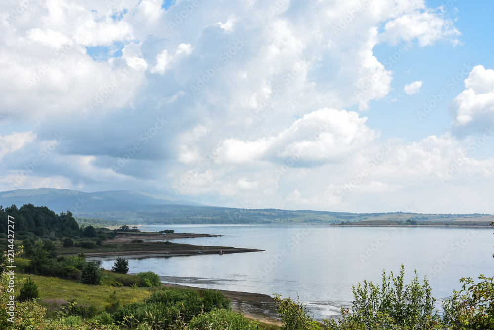 Beautiful cloudy sky over the mountain lake. Vlasina lake in eastern Serbia