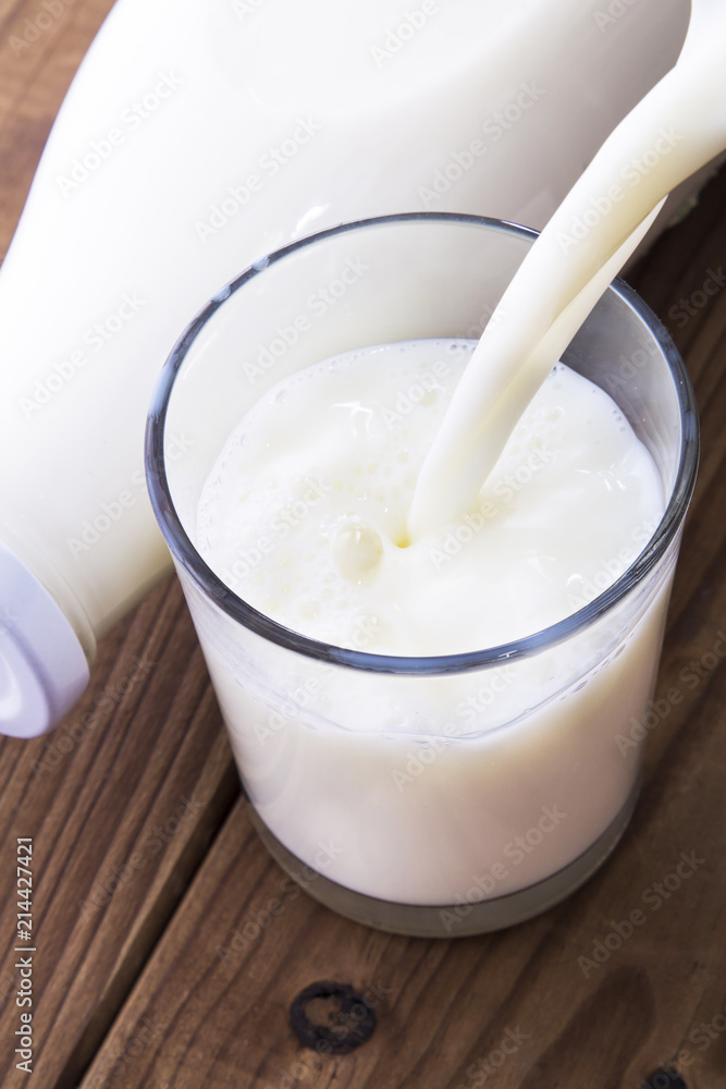 Dairy products. Bottle with milk and glass of milk on wooden table Dairy products. Bottle with milk and glass of milk on wooden table