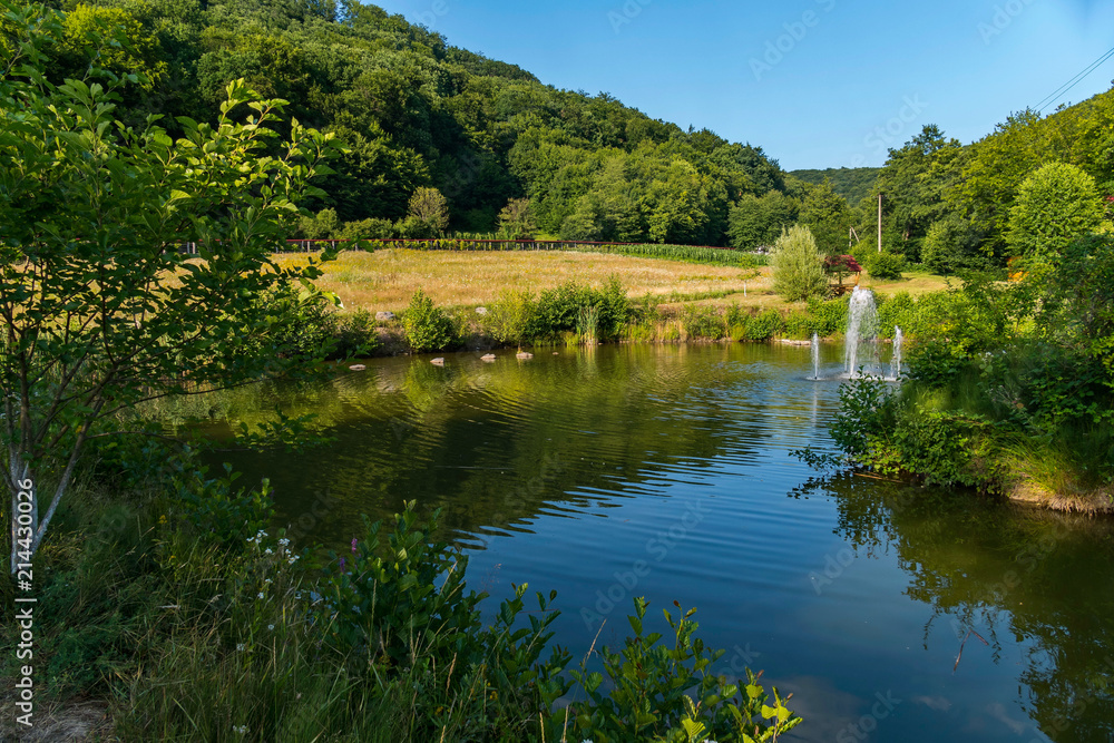 beautiful lake with a fountain and gazebo on the background of green mountains beautiful lake with a fountain and gazebo on the background of green mountains