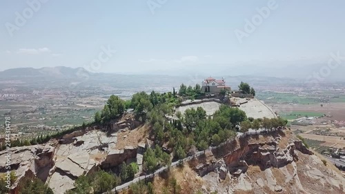 Hermitage in the top of hill surrounded by trees. photo