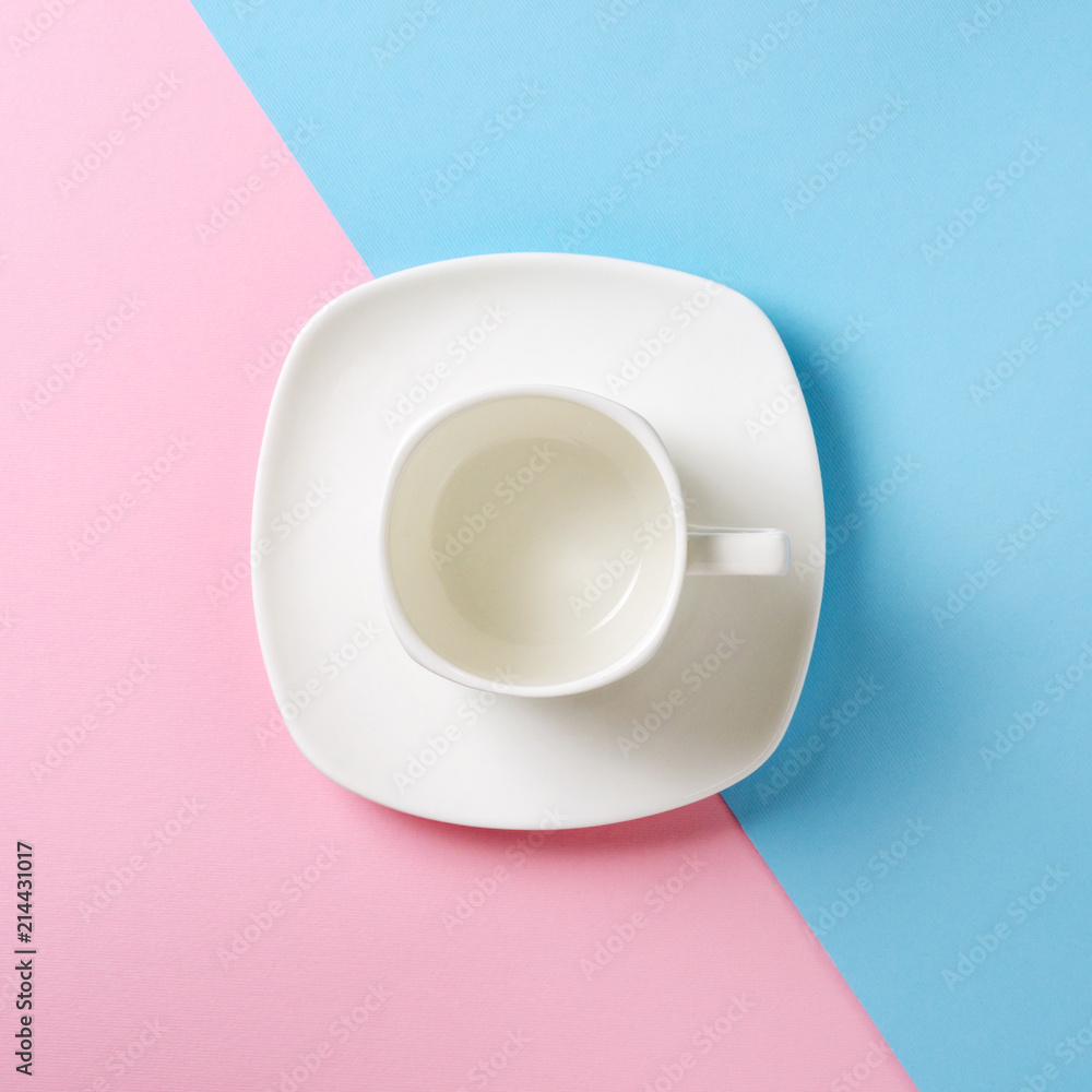 Empty white cup and saucer on a pink and blue background. Flat lay concept. Pastel shades Empty white cup and saucer on a pink and blue background. Flat lay concept. Pastel shades