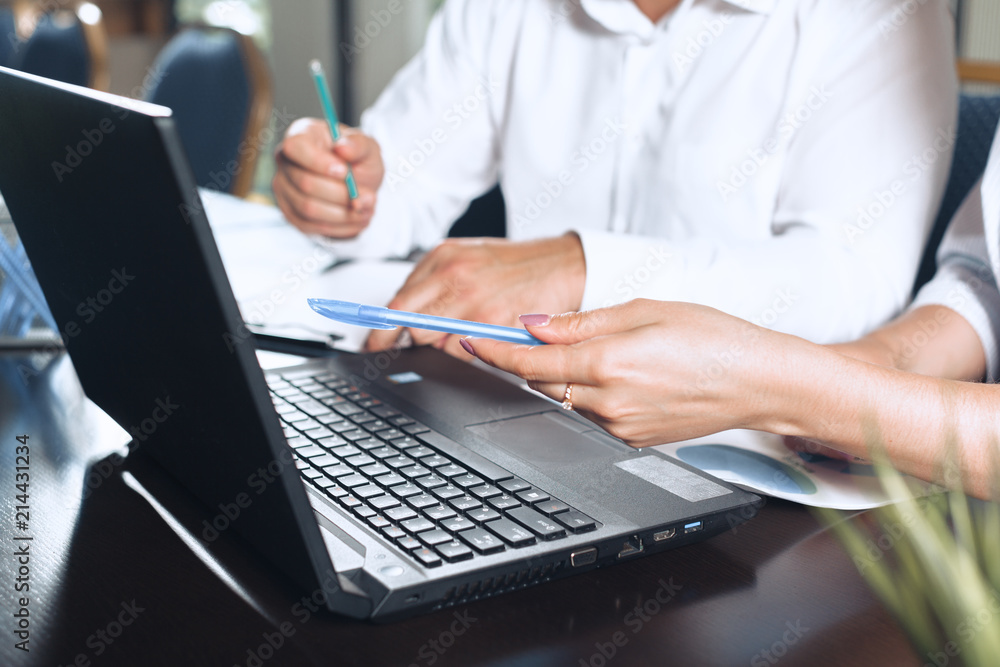 two business partners sitting at a table together and working. two business partners sitting at a table together and working.