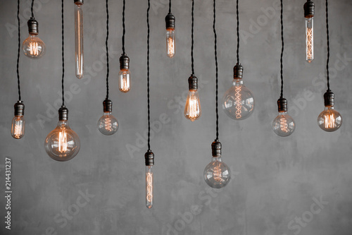 Fotografia Edison retro lamp Incandescent bulbs on gray plaster wall background in loft