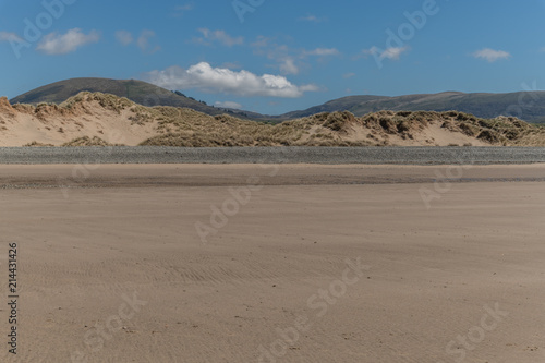 Sandy beach with sand dunes and distant hills