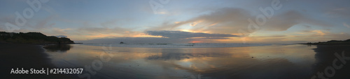 Spiegelung im Wasser am Sandstrand in Muriwai Beach