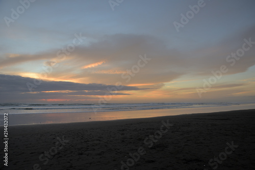 Spiegelung im Wasser am Sandstrand in Muriwai Beach