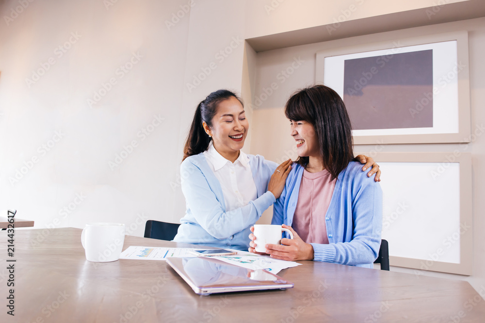 Asian family of middle aged woman and young teenage daughter talking and smiling at cafe restaurant Asian family of middle aged woman and young teenage daughter talking and smiling at cafe restaurant