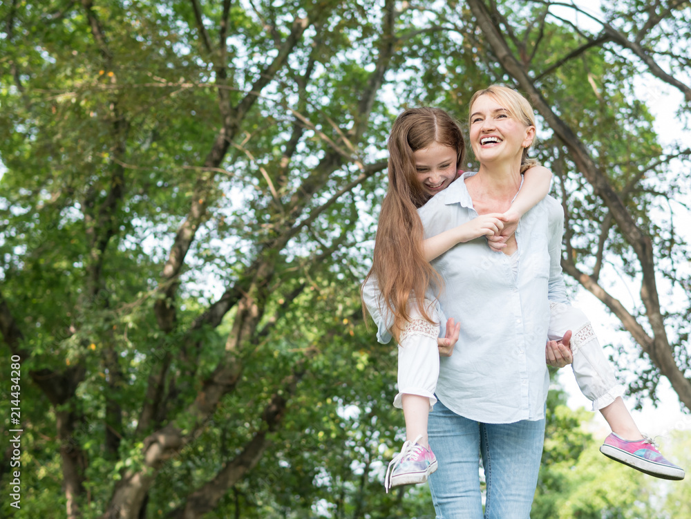 Mother and daughter playing together in the park. Happy family concept. Mother and daughter playing together in the park. Happy family concept.