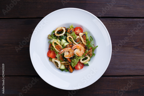 Seafood restaurant menu, mediterranean cuisine. Appetizing fresh vegetable and prawns salad, flat lay