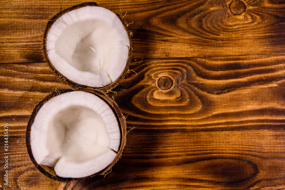 Ripe halved coconut on a wooden table. Top view Ripe halved coconut on a wooden table. Top view