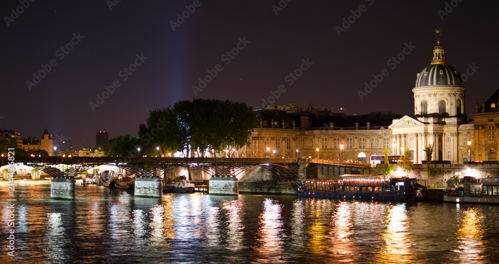 Night view of Paris and Pont des Arts bridge at the Seine, France