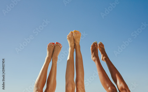 Close up of legs of three women raised up in the air