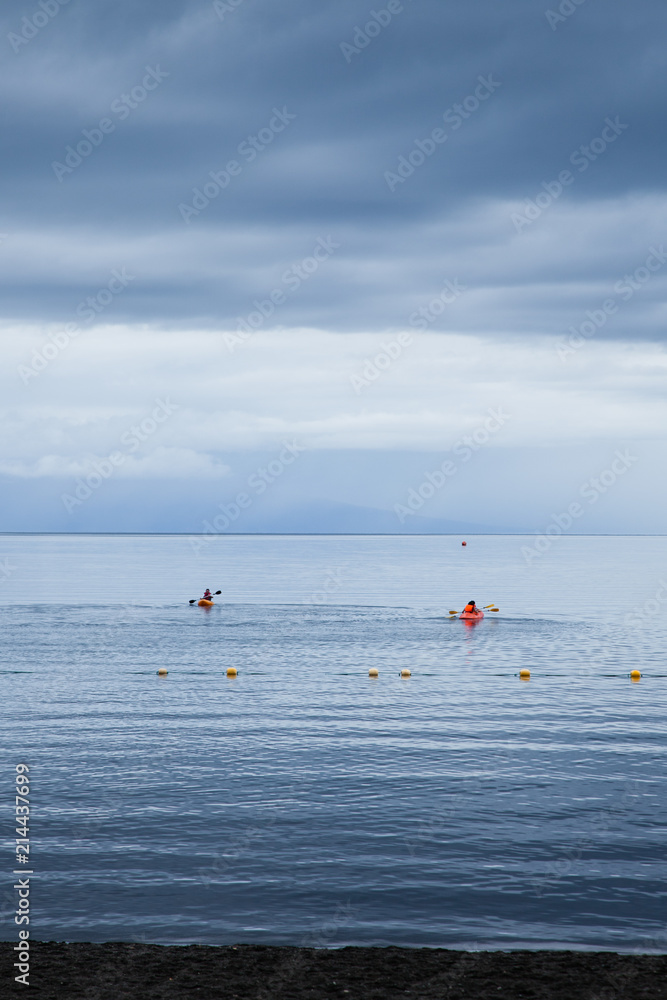 People sailing kayaks