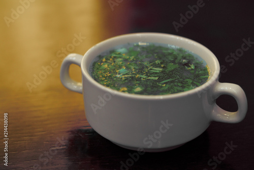 soup with fresh herbs on top in a plate on the table.