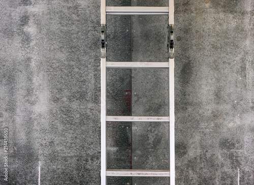 Step ladder near gray wall.