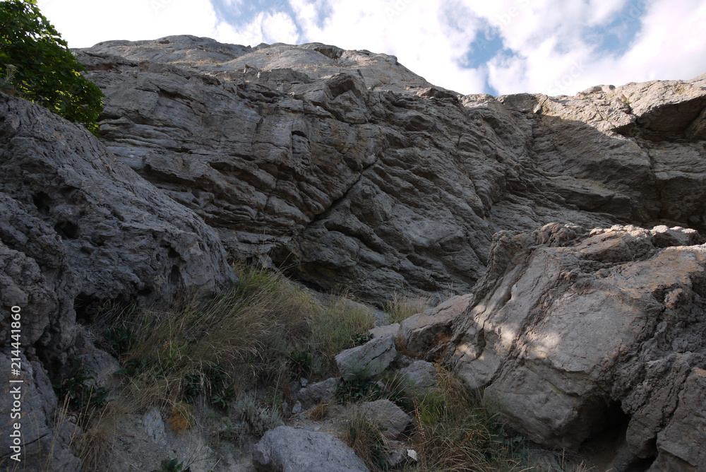 the tall rocky rocks are torn off with rains and dry grass winds