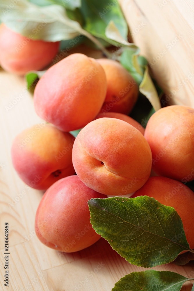 Apricots with leaves on a wooden table. Apricots with leaves on a wooden table.