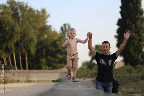happy family father son walking arms raised smiling