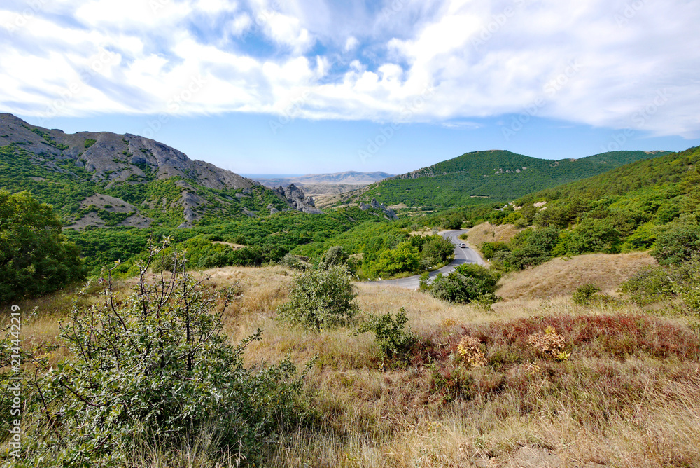 The highway is a serpent winding between mountain slopes covered with forest The highway is a serpent winding between mountain slopes covered with forest