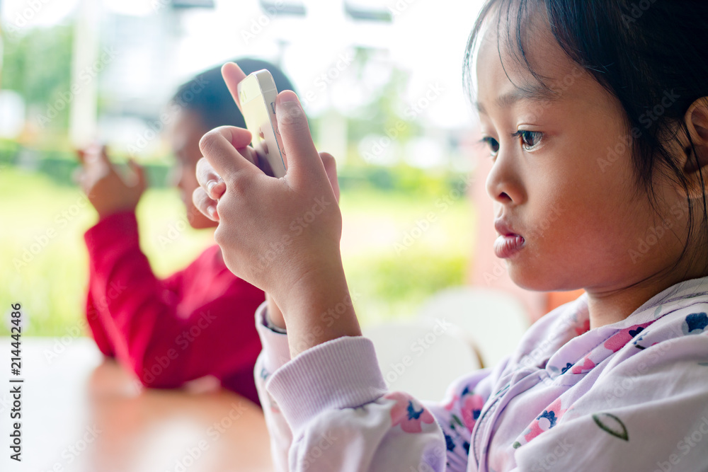 Little boy holding smartphone in horizontal position . Kid play game, surfing online, learning. Little boy holding smartphone in horizontal position . Kid play game, surfing online, learning.