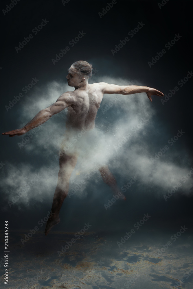 Dancing in flour concept. Muscle fitness guy man male dancer in light blue dust / fog. Guy making dance element in flour cloud. White ribbon as a symbol of lung cancer concept.