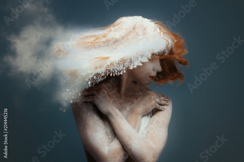 Dancing in flour concept. Cute fitness beauty redhead woman / female / adult dancer performer in dust / fog. Portrait of a girl dancer with ginger hair in flour on isolated backround