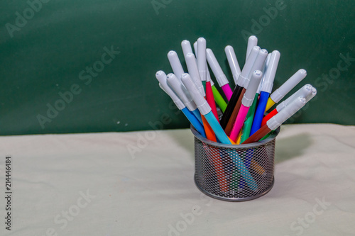Back to school background with pencils on  table over green wall