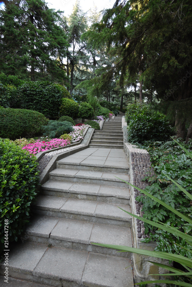 Large, long stairs between green spaces and flower beds in the park Large, long stairs between green spaces and flower beds in the park