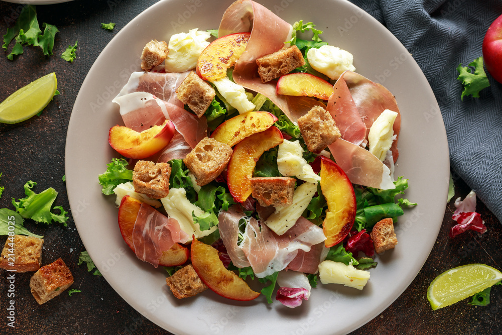 Fresh grilled peach salad with green mix, cheese, prosciutto and crouton