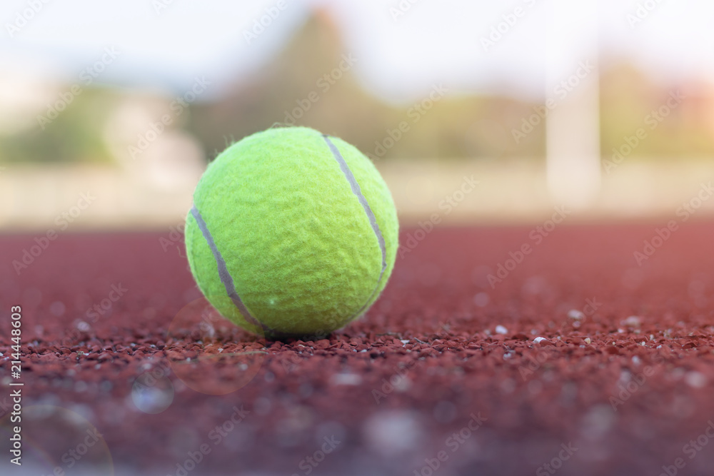 Close up ball is lying on the tennis court with sun flare.Close up ball is lying on the tennis court with sun flare.