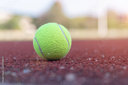 Close up ball is lying on the tennis court with sun flare.Close up ball is lying on the tennis court with sun flare. © NuPenDekDee
