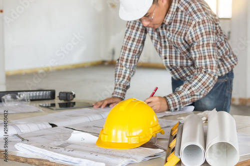 Engineer/ architect/ worker working about building plan for construction at job site. Construction equipment and blueprint on table at construction site.